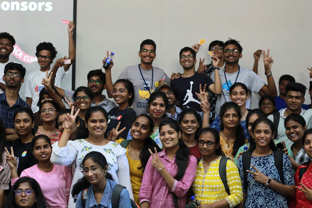 Hackathon participants celebrating together in a crowded group photograph